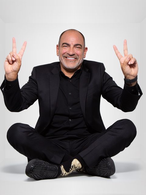 Brian Fabiano in a black suit, flashing two peace signs