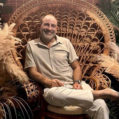 Brian Fabiano sitting in a rattan peacock chair